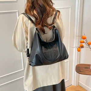 Minimalist black soft leather backpack with embossed logo and gold hardware details