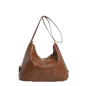 Sac fourre-tout en cuir marron avec logo circulaire gaufré et bandoulière spacieuse