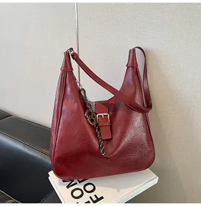 Detail of dark red vintage hobo bag with textured leather and silver metallic buckle