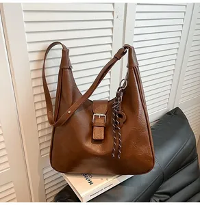 Detail view of brown vintage hobo bag with silver buckle and braided rope ornament