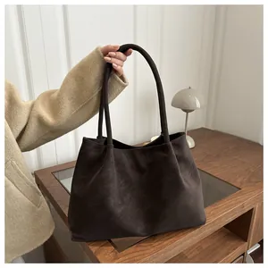 Dettaglio di una grande borsa tote vintage marrone caffè con texture in pelle opaca