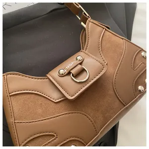 Detail of caramel brown moon bag with metal rivets and premium PU leather textures