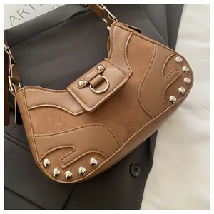 Detail shot of brown shoulder bag showing textured PU leather and silver rivet hardware