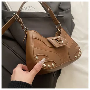 Close-up of brown leather stitching and silver rivet details on a retro hobo shoulder bag