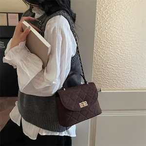 Dunkelbraune gesteppte Umhängetasche mit matter Veloursleder-Textur und Goldkette