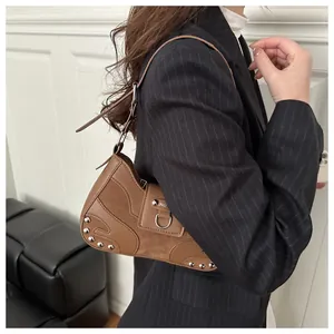 Brown rivet hobo bag with patchwork leather and metal buckle detail on shoulder strap