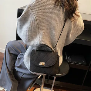 Elegante schwarze Stepptasche mit goldenem Drehverschluss und Kettenriemen für Damen