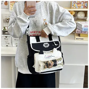 Close-up of contrast canvas messenger bag featuring a clear window with plush doll charm