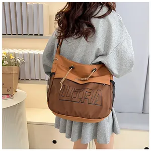 Detail of khaki canvas tote bag featuring black mesh pocket and WIRA logo decoration