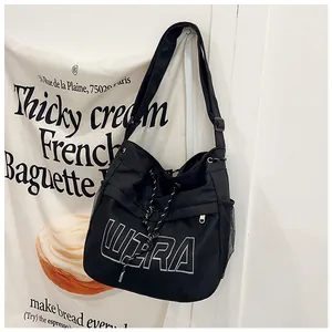 Detail of black tote bag featuring white WIRA lettering and mesh side pocket