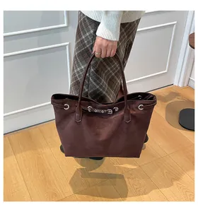 Braune Shopper-Tasche aus Wildlederimitat mit Schnalle und Ösen, getragen von Model