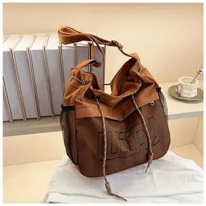 Close-up of brown tote bag with ULTRA lettering and mesh detail in a minimalist setting