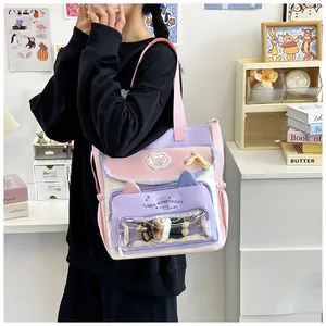 Detail view of pink and purple canvas tote bag with transparent PVC window and plush bear