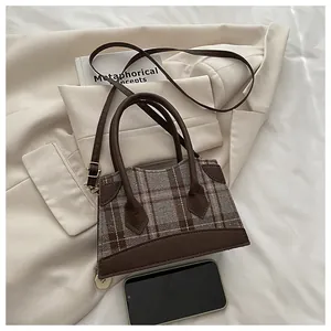 Vue détaillée d'un mini sac à main à carreaux anglais avec finitions en cuir marron