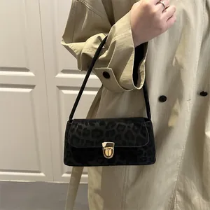 Sac baguette noir élégant avec motif léopard sombre et boucle dorée raffinée