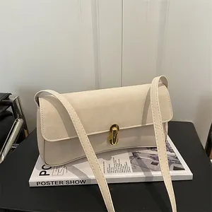 Dettaglio di borsa a spalla minimalista bianco crema con chiusura a scatto dorata