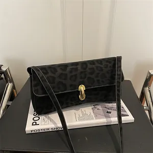 Dettaglio della borsa a tracolla leopardata nera con elegante chiusura a scatto dorata