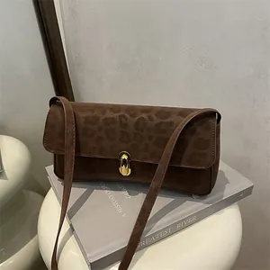 Dettaglio della borsa a spalla leopardata con elegante chiusura a scatto in metallo dorato