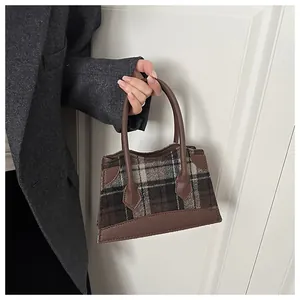Détail du tissu en laine à carreaux et des coutures en similicuir du petit sac