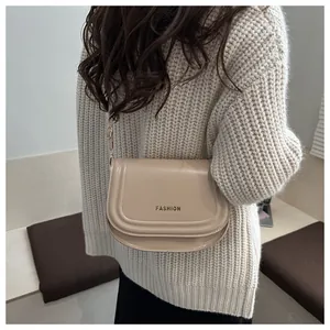 Détail d'un sac besace beige avec imprimé fashion et texture en similicuir matifié