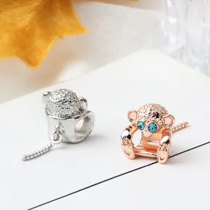 Detalle de cuentas de mono en oro rosa y plata con ojos de cristal azul para pulseras DIY