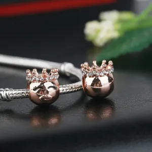 Rose gold crown charms with sparkling crystals on a silver snake chain bracelet