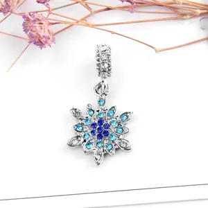 Sparkling snowflake pendant with blue and white crystals on a clean white background