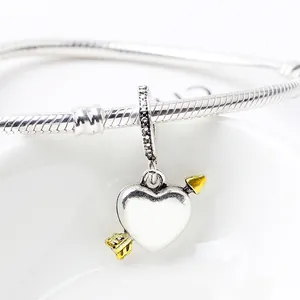 Makroaufnahme von Amor-Herzanhänger mit Goldakzenten und Zirkonia auf Schlangenarmband