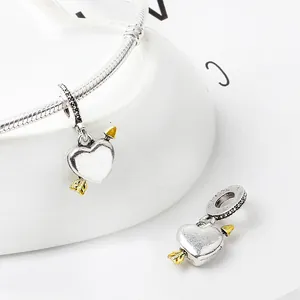 Makroaufnahme von Silber-Cupid-Herzanhänger mit Goldpfeil auf Schlangenkette