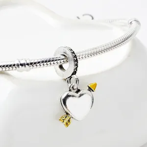 Cupido-Herzanhänger an einem silbernen Schlangenarmband mit goldenen Akzenten