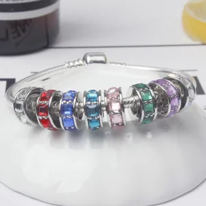 Silbernes Schlangenarmband mit sieben bunten Kristallanhängern in der Draufsicht