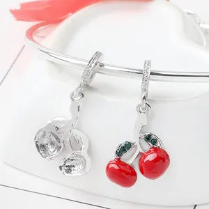 Macro di charm a ciliegia in smalto rosso con gemme verdi e cristalli su bracciale d'argento