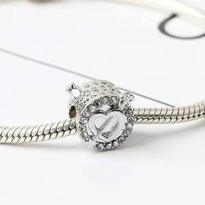 Gros plan d'un charm coeur en argent avec zircone et flèche sur bracelet maille serpent