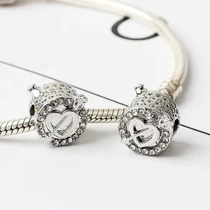 Détail des charms cœur argentés avec pierres pavées et flèche sur bracelet maille serpent