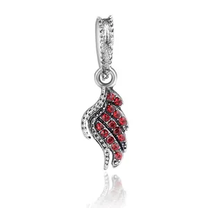 Silver wing charm with micro-set red crystals and polished cylinder bail on white background