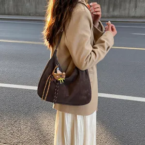 Dark brown frosted hobo tote bag with bear charm shown on model in street style