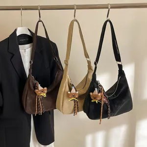 Three minimalist matte suede tote bags in dark brown, beige, and black with bear charms