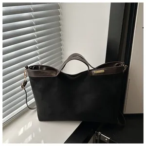 Détail du sac cabas en suède avec doublure léopard et plaque métallique dorée