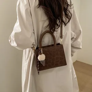 Brown leopard print suede handbag for women with plush charm and shoulder strap