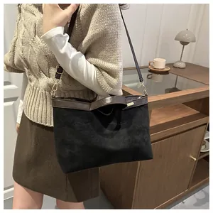 Détail du sac cabas bicolore en daim avec lanières en cuir et boucles dorées