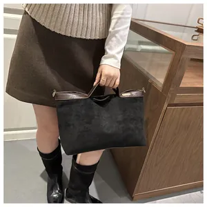Vue détaillée du grand sac cabas avec texture mate noire et anses en cuir marron foncé