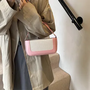 Detail of pink leather and beige canvas stitching on the retro baguette shoulder bag