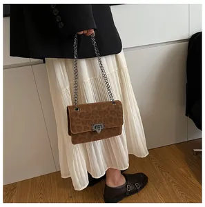 Close-up of leopard print crossbody bag with metallic chain strap and vintage clasp