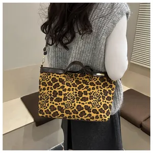 Détail du sac cabas à imprimé léopard et roses avec anses en cuir et logo doré brillant