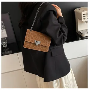 Detailed view of leopard print shoulder bag with silver chain strap on model back