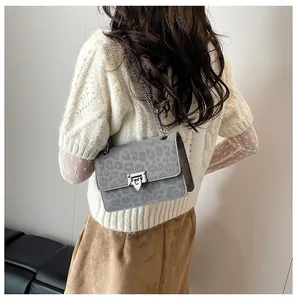 Detail of grey leopard print crossbody bag with silver chain strap on model back