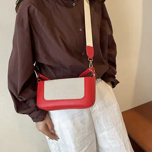 Contrast color rectangular crossbody bag with red leather and wide cream fabric strap