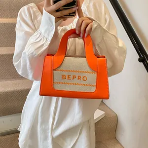 Detailweergave van de oranje en beige canvas patchwork tas met geprint BEPRO-logo op de tas