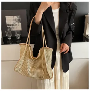 Detail of large woven straw tote bag with brown leather handles for beach and daily commute