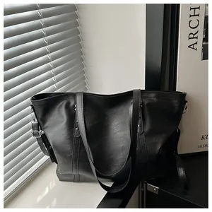 Detail of black leather tote bag showing star metal rivets and silver buckle hardware